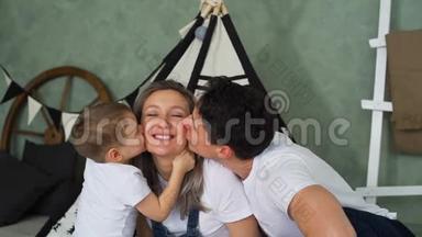 父亲和儿子在托儿所亲吻怀孕的母亲